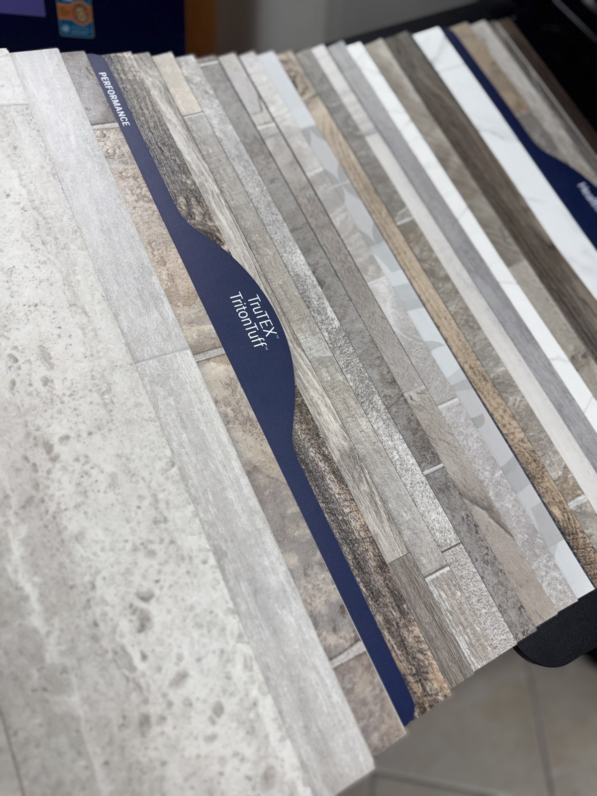 A Mannington Performance sheet vinyl sample book open to TruTEX and TritonTuff samples in stone, slate, marble, and wood looks