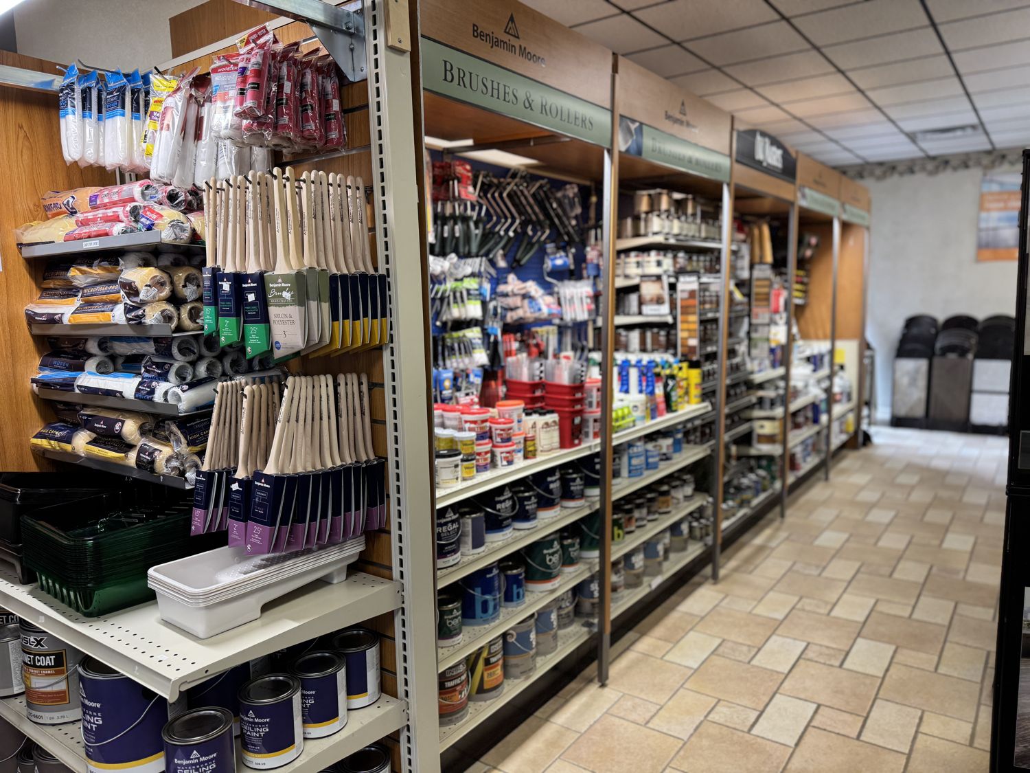 The brushes and rollers aisle at A & A Decorative, with Benjamin Moore displays, Old Masters stains, and paint on the shelves