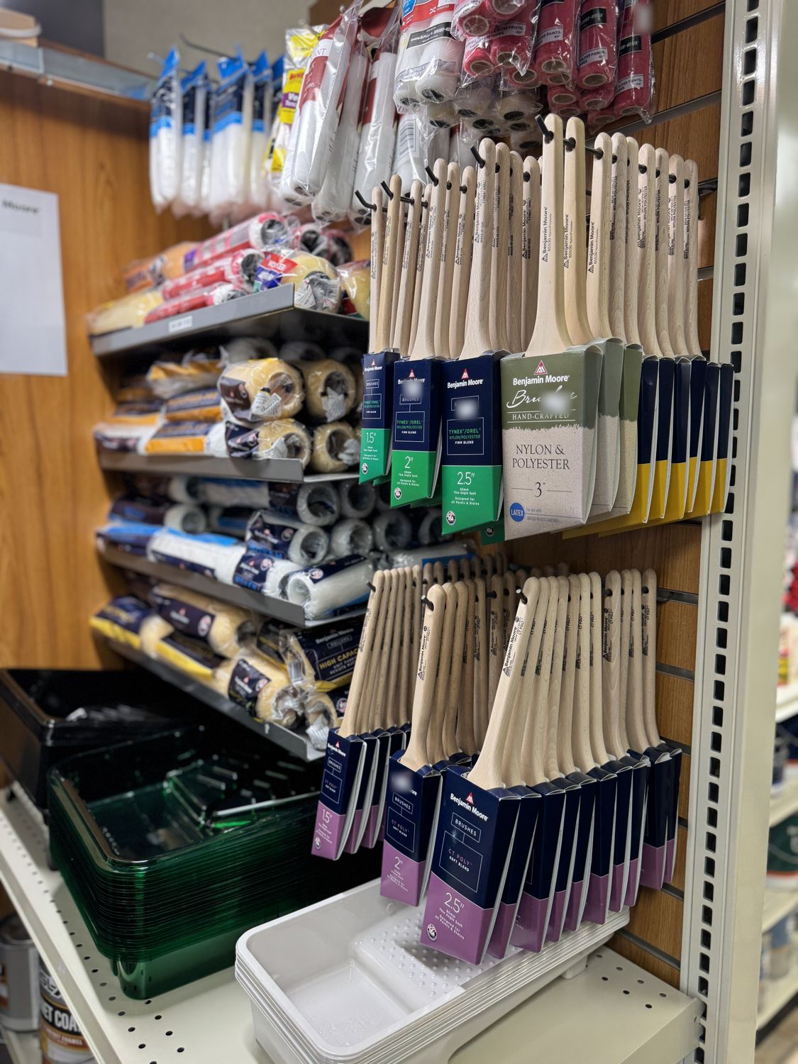 Benjamin Moore brushes and roller covers hanging on the wall at A & A Decorative