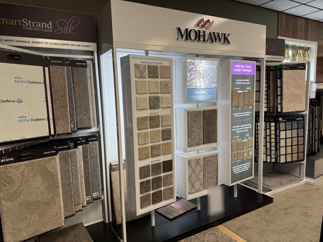 The Mohawk SmartStrand Silk display, with carpet samples grouped by color and a stain and wear demonstration